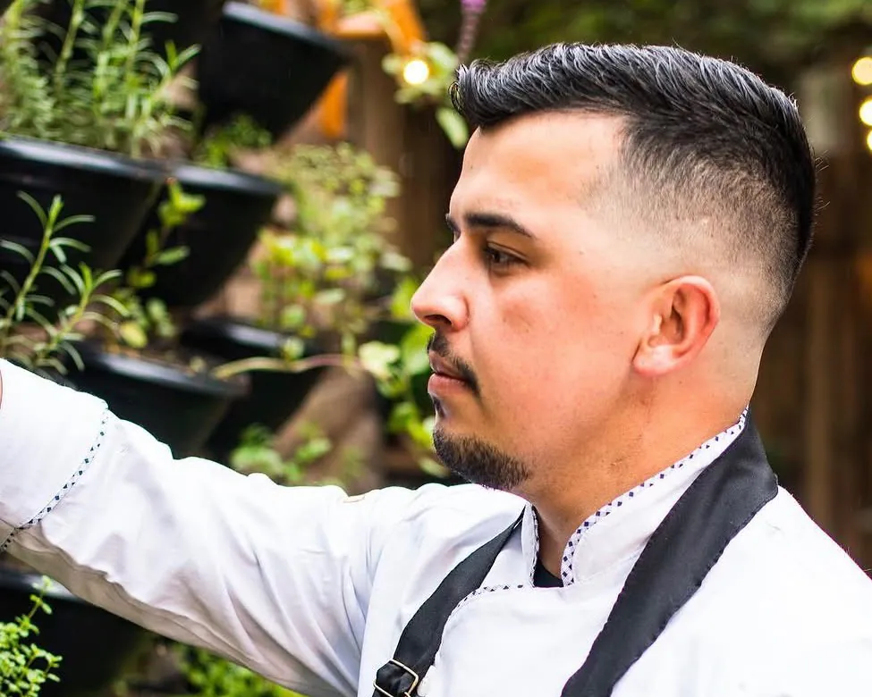 O chef Vinícius Galvão colhendo ervas na horta